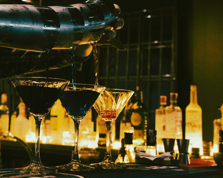 Bartender pouring cocktails in a dimly lit bar