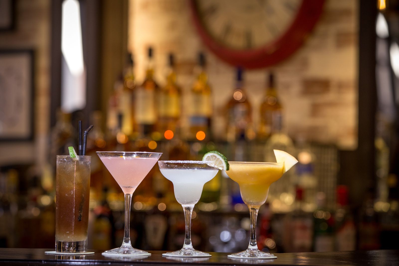 Row of colorful cocktails on a bar counter, the kind of drink covered by cruise drink packages