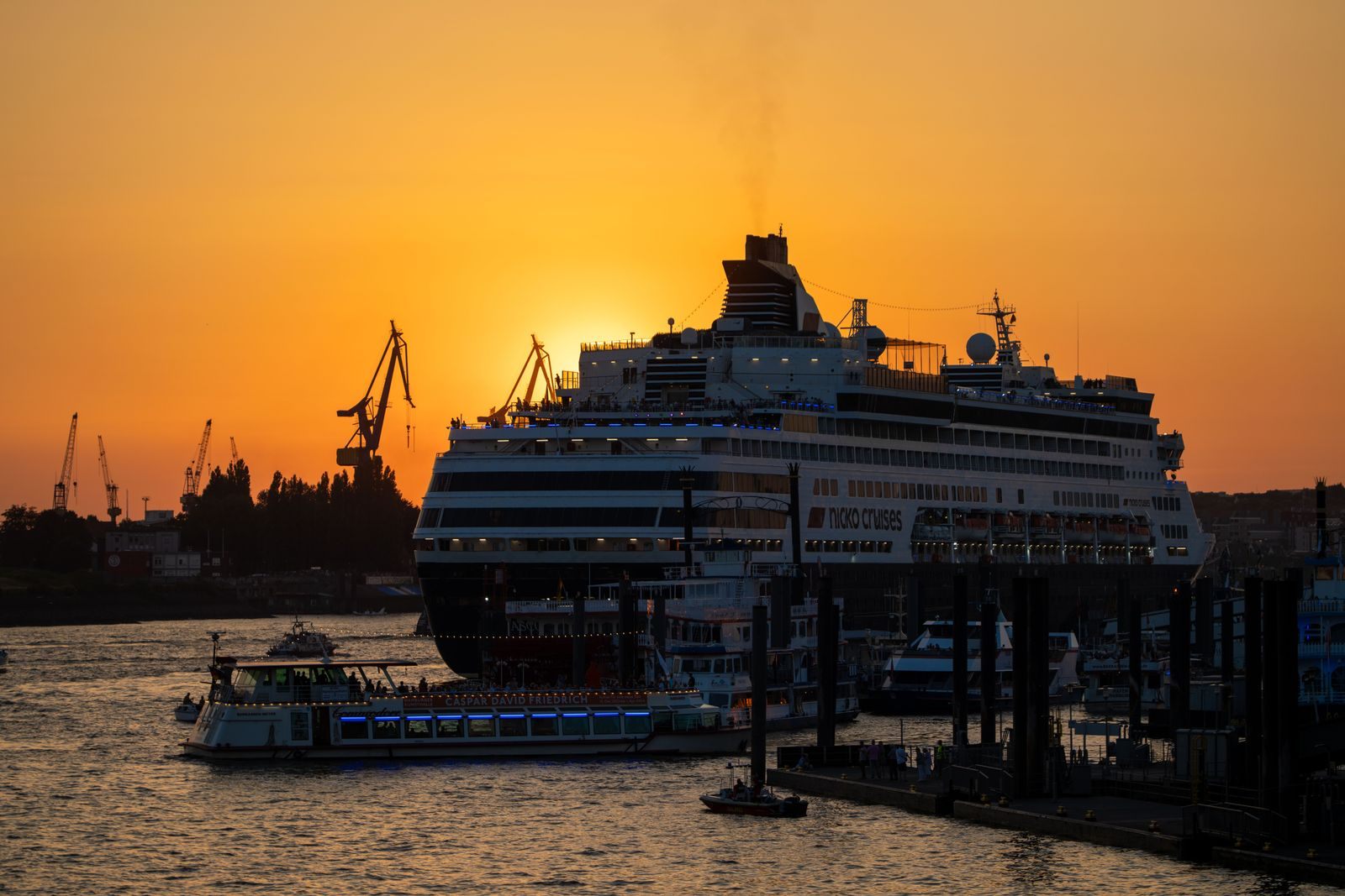 Cruise ship docked in Hamburg harbor at a golden sunset